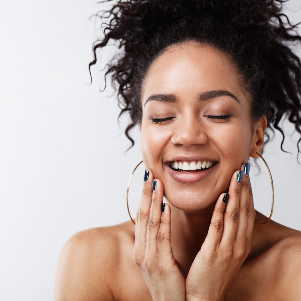 Woman touching face enjoying Clean Coconut Skincare Products
